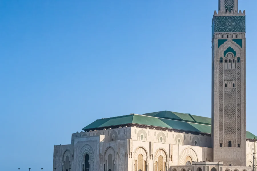 Hassan II Mosque, Casablanca – Morocco’s Architectural Masterpiece on the Atlantic Ocean The Hassan II Mosque in Casablanca is one of the most iconic landmarks in Morocco and a must-see destination for travelers visiting North Africa. Overlooking the Atlantic Ocean, this extraordinary mosque is a symbol of Morocco’s religious devotion, artistic excellence, and modern architectural ambition. As one of the largest mosques in the world, the Hassan II Mosque attracts visitors from the United States and around the globe who seek cultural depth, history, and breathtaking design. A Monument of Faith and Vision Commissioned by King Hassan II and completed in 1993, the mosque was built to honor Morocco’s spiritual heritage while showcasing the finest Moroccan craftsmanship. Its minaret rises to 210 meters (689 feet), making it the tallest mosque minaret in the world. Partially constructed over the ocean, the mosque reflects a verse from the Quran that states “God’s throne was built upon the water.” This unique location creates a powerful connection between faith, nature, and architecture. Moroccan Artistry at Its Finest The Hassan II Mosque is a masterpiece of traditional Moroccan art. More than 6,000 skilled artisans worked on the mosque, using techniques passed down through generations. Visitors are amazed by: • Hand-carved cedar wood ceilings • Intricate zellige tile mosaics • Marble floors and sculpted plaster • A retractable roof that opens to the sky Every detail reflects Morocco’s rich artistic heritage and dedication to perfection. One of the Few Mosques Open to Non-Muslims Unlike many mosques in the Islamic world, the Hassan II Mosque welcomes non-Muslim visitors through guided tours. This makes it especially appealing to American travelers seeking cultural understanding and authentic experiences. Guided visits provide insight into: • Islamic architecture and symbolism • Moroccan religious traditions • The mosque’s construction and history Visiting Hassan II Mosque Today Located in the heart of Casablanca, Morocco’s largest city, the mosque is easily accessible and often combined with city tours, coastal walks, and visits to the old medina. The best times to visit are: • Morning or late afternoon for soft light • Sunset, when the mosque glows above the ocean Comfortable clothing and respectful attire are recommended. Experience Hassan II Mosque with Moroccan Odyssey At Moroccan Odyssey, we include the Hassan II Mosque in many of our private and customized Morocco tours. Our experienced local guides provide deep historical context and ensure a smooth, meaningful visit for travelers from the USA and worldwide. Whether you are starting your journey in Casablanca or ending your Morocco tour by the Atlantic coast, the Hassan II Mosque is an unforgettable highlight. Why Hassan II Mosque Is a Must-See in Morocco • One of the largest mosques in the world • Tallest minaret globally • Open to non-Muslim visitors • Stunning oceanfront location • Masterpiece of Moroccan craftsmanship • Top attraction for US travelers to Morocco