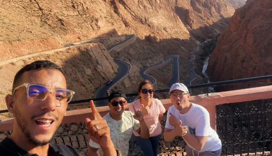 Nestled between rugged red-rock mountains in the south of Morocco, Dades Gorge is one of the country’s most breathtaking natural wonders. Known for its dramatic landscapes, deep valleys, and impressive rock formations, this region is a highlight for travelers seeking adventure, beauty, and authentic Moroccan culture. One of the most iconic attractions inside the Dades Valley is the Amsmimer Zigzag Road, often called the “Tizi n’Tissdrine Road” — a serpentine stretch of mountain road famous for its sharp bends and extraordinary panoramic views. For many visitors, the journey through the Dades Gorge feels like stepping into another world. Towering canyon walls rise dramatically on both sides, shaped over thousands of years by the Dades River. This unique landscape attracts photographers, nature lovers, and travelers in search of untouched beauty. When exploring this region on a private tour in Morocco, the experience becomes deeper and more personal, offering guests the chance to discover hidden viewpoints, local villages, and Berber traditions along the way. During one of our recent adventures with Moroccan Odyssey, our guide accompanied three wonderful guests from Indonesia — Dwi, Drazat, and Fendi. The group enjoyed a sunny afternoon at one of the most spectacular viewpoints overlooking the zigzag mountain road of Amsmimer. Their joyful expressions, big smiles, and excitement captured the true spirit of travel: connection, happiness, and the thrill of discovering a new destination. The picture taken at this viewpoint shows the group standing above the winding road, surrounded by the warm colors of the Dades mountains. The dramatic curves of the road make the scene unforgettable and represent the adventurous essence of the Moroccan south. This moment reflects the high-quality, personalized service that Moroccan Odyssey offers on every private tour, ensuring that guests feel safe, guided, and inspired throughout the journey. Exploring the Dades Gorge with Moroccan Odyssey also provides travelers with exclusive access to storytelling, local experiences, and cultural insights. Our guides are passionate about sharing the history of the region, the geology of the canyon, and the traditional life of the Amazigh communities who have lived here for centuries. Whether visitors are traveling as families, friends, couples, or solo explorers, the scenic routes of Dades Valley always leave a lasting memory. If you are planning a trip to Morocco and want to immerse yourself in the beauty of the south — from the High Atlas Mountains to the Sahara Desert — the Dades Gorge and its famous zigzag road should be at the top of your list. And with Moroccan Odyssey, your private tour will be designed with care, comfort, and authenticity. We ensure that every guest, like Dwi, Drazat, and Fendi, experiences Morocco in the most unforgettable way. Exploring the Iconic Dades Gorge Zigzag Road in South Morocco – Private Guided Tour with Moroccan Odyssey and Indonesian Guests Dwi, Drazat & Fendi Private Morocco Tour Through the Dades Gorge and Amsmimer Zigzag Road – Stunning Mountain Experience with Moroccan Odyssey and Guests Dwi, Drazat & Fendi from Indonesia Unforgettable Dades Gorge Experience on the Iconic Zigzag Road – Epic South Morocco Adventure with Moroccan Odyssey and Indonesian Guests Dwi, Drazat & Fend