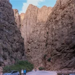 Travelers walking between the towering canyon walls of Todra Gorge Morocco