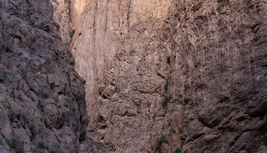 Travelers walking between the towering canyon walls of Todra Gorge Morocco