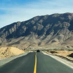 Mountain road in southern Morocco with dramatic Atlas Mountains under a clear blue sky