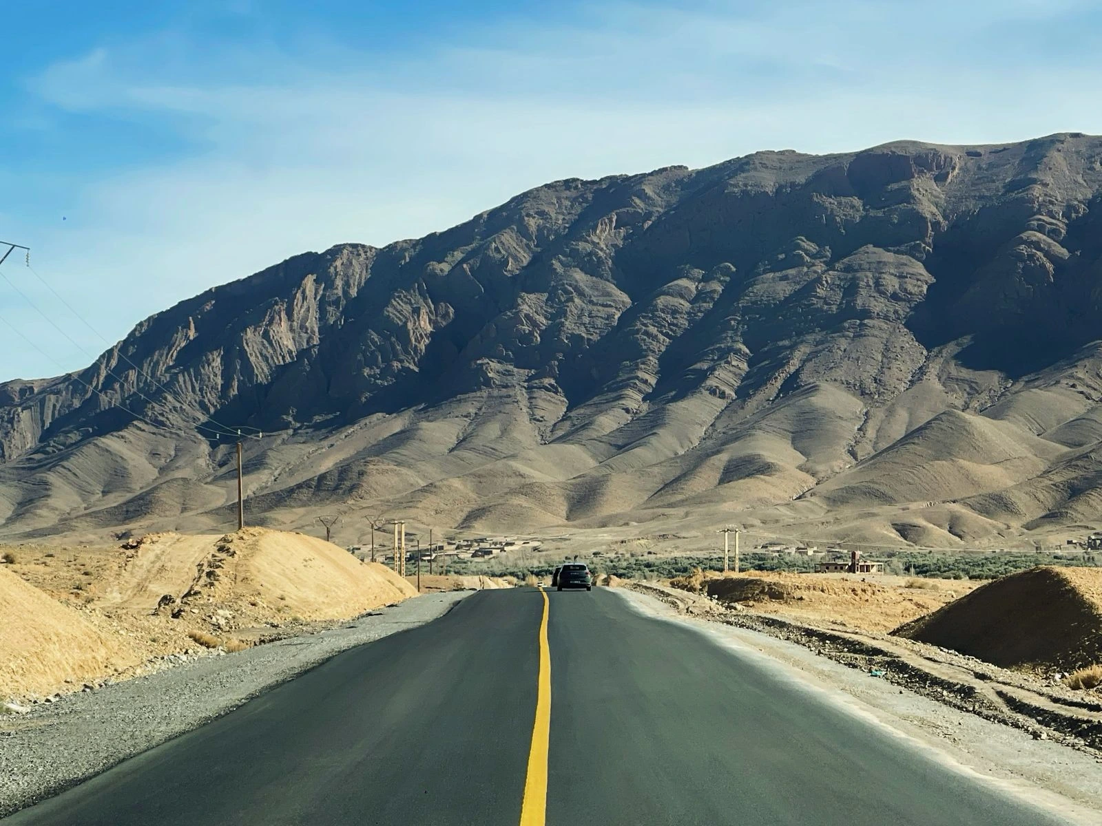 Mountain road in southern Morocco with dramatic Atlas Mountains under a clear blue sky