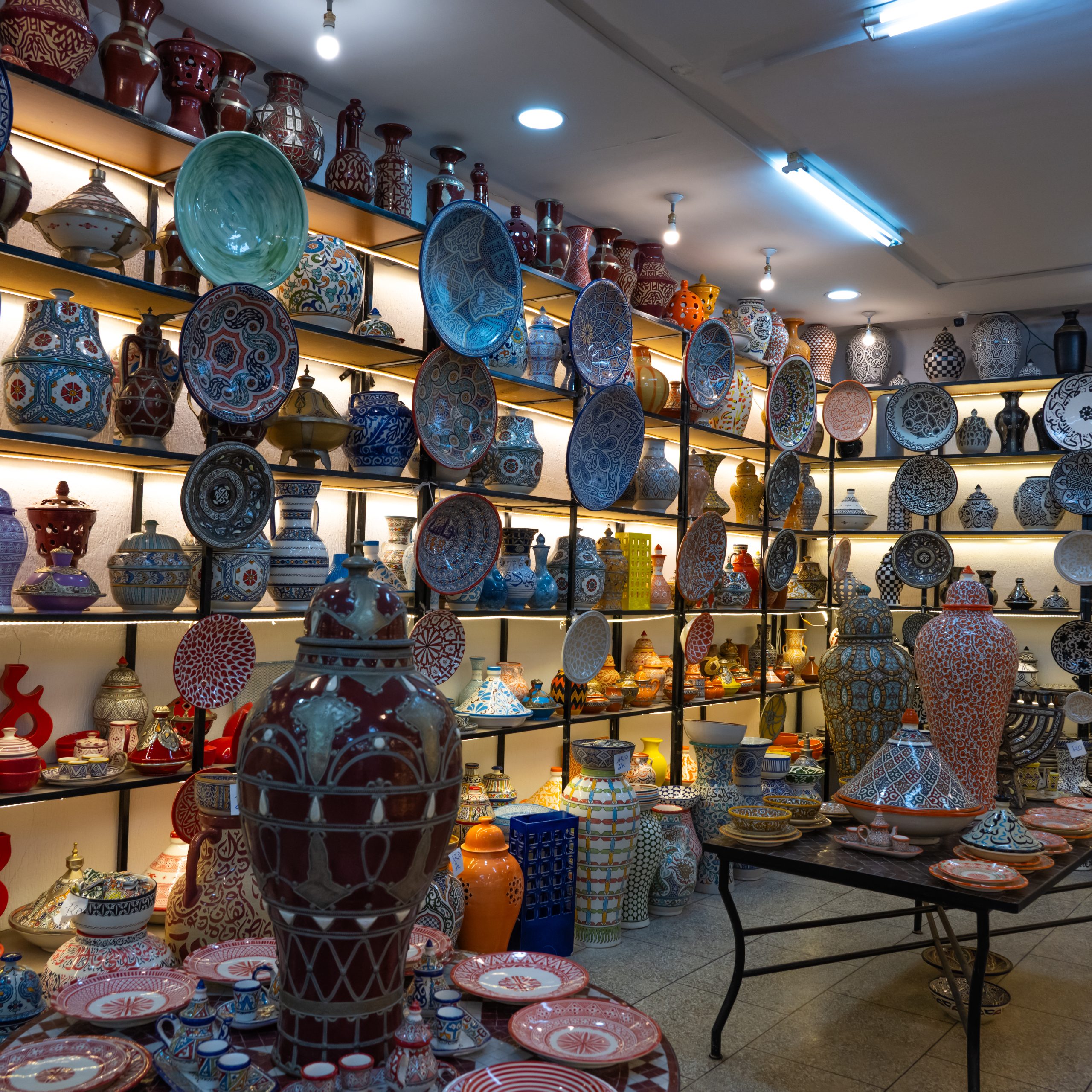 Traditional Fes pottery workshop inside the Medina of Fes, Morocco with handmade blue ceramic plates and tagines