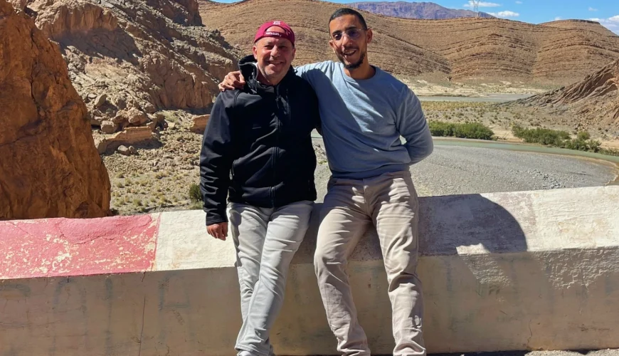 Guest and local guide enjoying a scenic stop in Dades Valley, Morocco, with stunning mountain landscapes and river views during a private desert tour