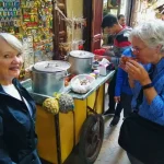 Guests enjoying traditional Moroccan snail soup in a local market setting.