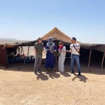 Travelers visiting a traditional nomad family in the Sahara Desert of Morocco and learning about their authentic way of life.