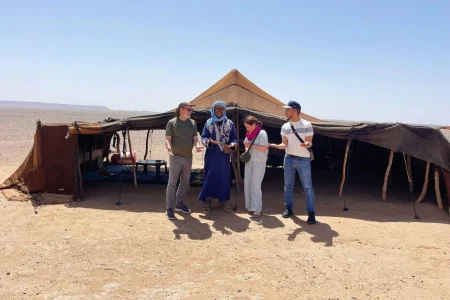 Travelers visiting a traditional nomad family in the Sahara Desert of Morocco and learning about their authentic way of life.