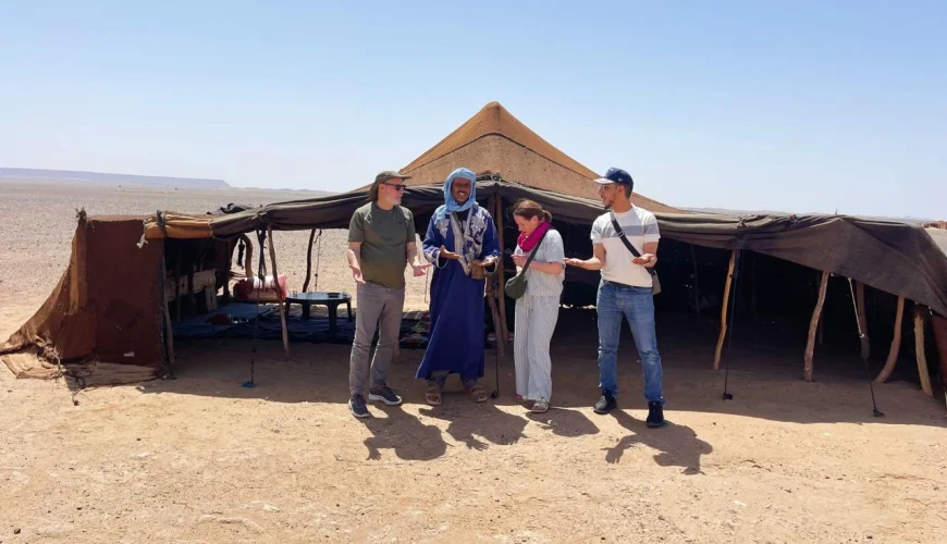 Travelers visiting a traditional nomad family in the Sahara Desert of Morocco and learning about their authentic way of life.