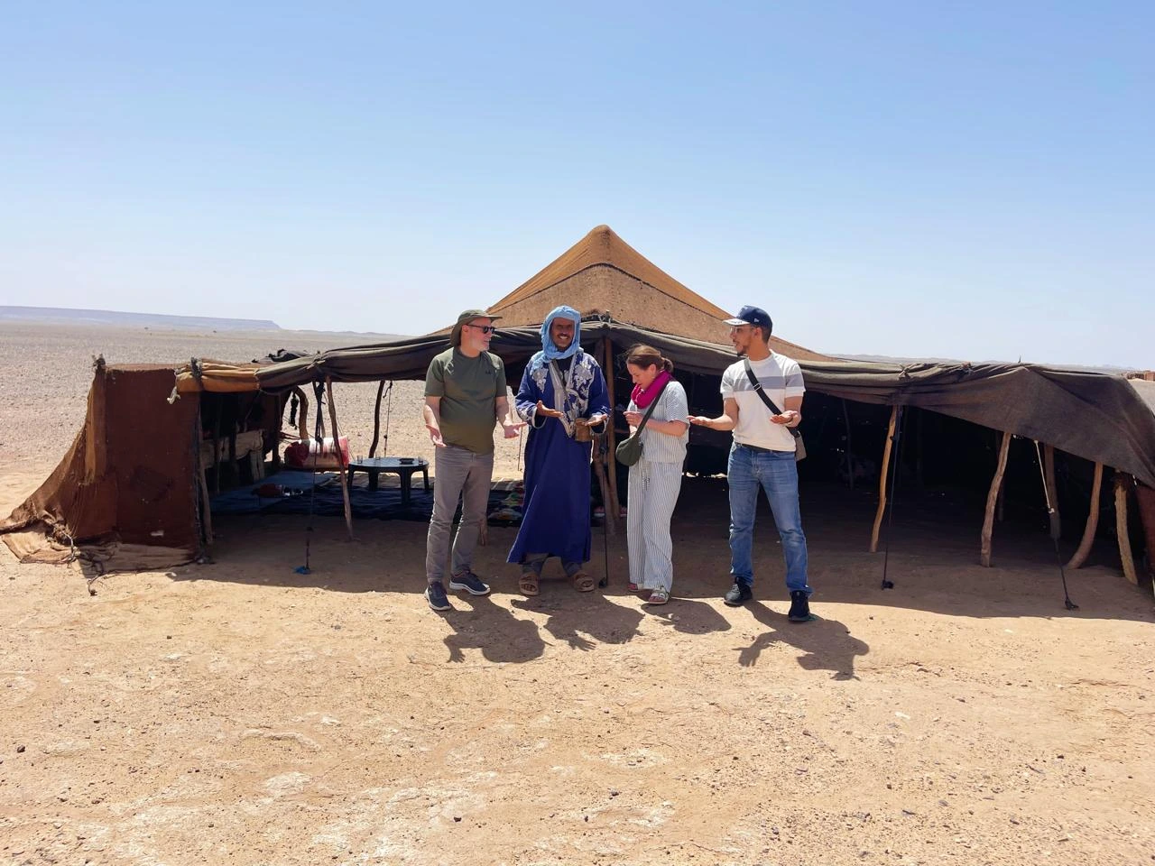 Travelers visiting a traditional nomad family in the Sahara Desert of Morocco and learning about their authentic way of life.
